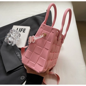 Detail of pink EVA woven tote bag showing texture, dual handles and golden metal buckle