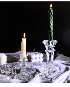 Close-up of geometric crystal glass candle holders with elegant warm candlelight on black