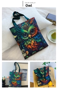 Detail of owl print canvas tote bag with deep blue base and green webbing handle