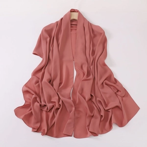 Silky pink chiffon headscarf with soft drapes and smooth texture on wooden hanger