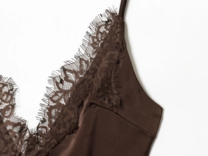 Gros plan sur la dentelle cil et le satin marron lisse au niveau du décolleté