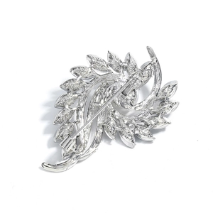 Back view of silver feather brooch showing pin mechanism and rotating flower structure