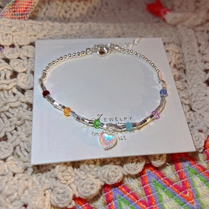 Dettaglio macro del bracciale in argento S925 con cristalli colorati e ciondolo a cuore