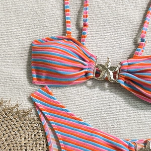 Detail of colorful striped bikini top featuring a gold starfish buckle and ribbed fabric
