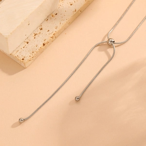 Close-up of silver steel snake chain necklace with round beads and Y-shape drop design