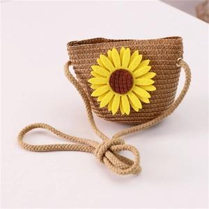 Detail of straw woven crossbody bag for kids featuring a bright yellow sunflower deco