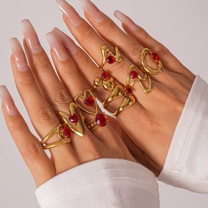 Dettaglio di anelli vintage dorati con pietre rosse a cuore e design a strati eleganti