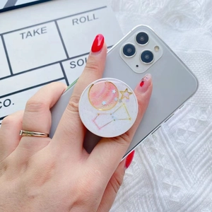 Handheld celestial galaxy pop socket with glitter stars and planets on a smartphone