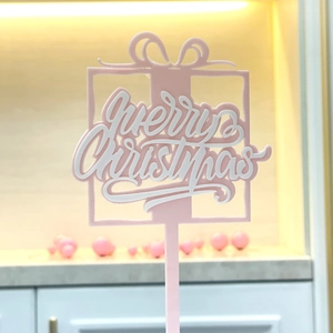 Pink and white acrylic Merry Christmas cake topper in a festive gift box style design