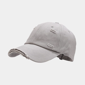 Close-up of distressed details and frayed edges on the gray vintage style baseball cap