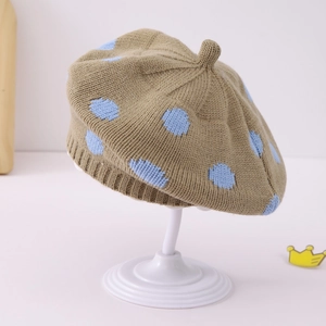 Detail of khaki knitted beret featuring blue polka dots and elastic ribbed edge