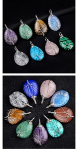 Detailed arrangement of Tree of Life crystal pendants wrapped in silver wire on black fabric