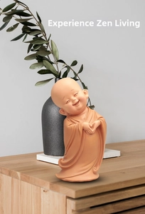 Detail of a smiling Zen monk car ornament with sand glaze finish and serene pose