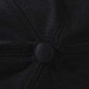 Close-up of the top button and stitching detail on a black hip-hop denim baseball cap