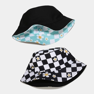 Reversible bucket hat featuring daisy print, checkerboard pattern and sun protection