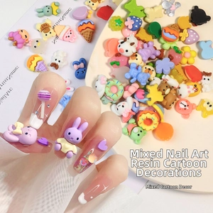 Dettaglio di ciondoli in resina colorata su unghie lunghe per nail art creativa fai-da-te
