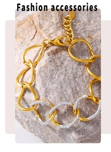 Detail showing gold thick chain bracelet with white crystal rhinestones on rock