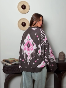 Detail view of ethnic geometric jacquard pattern on the back of a brown knit sweater