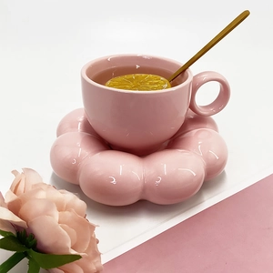 Detailed view of a pink petal-shaped ceramic coffee cup set on a white background