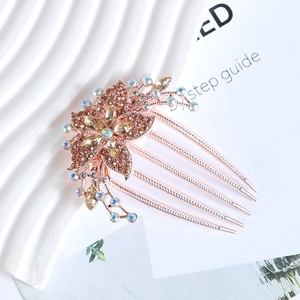 Detailed view of rose gold flower hair comb with champagne and iridescent rhinestones