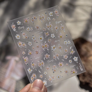 Macro view of 3D embossed nail stickers featuring pink cosmos flowers and delicate blossoms
