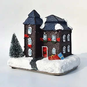 Close-up of glowing Christmas snow house with mini tree and LED lights decor