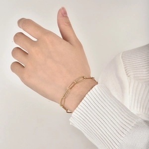 Minimalistisches goldenes Büroklammer-Kettenarmband für Damen, getragen am Handgelenk