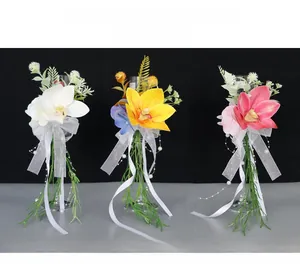 Detail view of artificial white, yellow, and pink orchids with pearls for wedding glasses