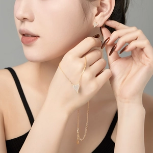 Detailed view of gold S925 silver heart jewelry set with pavé cubic zirconia on model