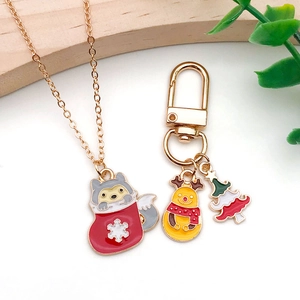 Christmas enamel charms set featuring Santa raccoon necklace and festive tree keychain