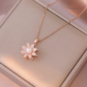 Rose gold necklace featuring a pearl flower pendant with cubic zirconia on a jewelry box