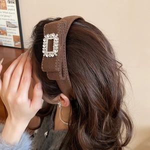 Macro detail of the brown wool velvet headband with a luxury rhinestone square buckle