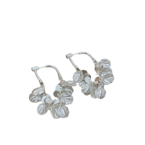 Silver geometric hoop earrings with metallic leaf tassels on a clean white background