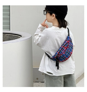 Rear view of a boy wearing a blue and red plaid crossbody chest bag over a white shirt