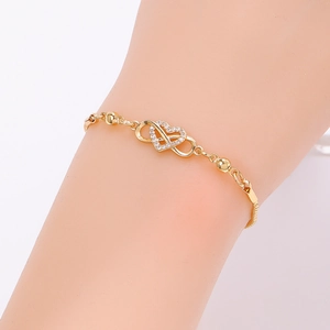 Close-up of gold double hollow heart bracelet with pavé white zircons and beads