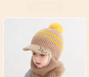 Detail der Kinder-Strickmütze mit gelbem Bommel und Stern-Patch in khakifarbenem Stoff