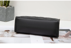 Macro shot of black quilted faux leather crossbody bag with detailed rhombus stitching