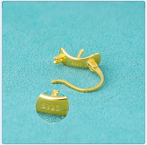 Detailed macro view of gold-plated S925 sterling silver earring clasp with hallmark