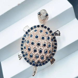 Detailed view of cute turtle brooch featuring sparkling blue rhinestones and elegant gold tone.