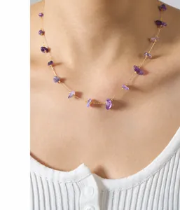 Close-up of handmade necklace with natural purple stones on stainless steel chain