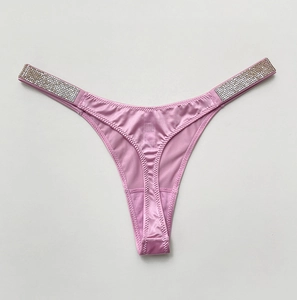 Close-up of pink satin thong with sparkling rhinestone side straps and polished finish