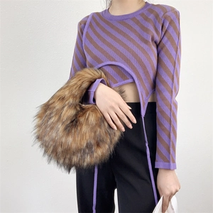 Close-up of fluffy faux fur handbag with striped y2k knit top on model