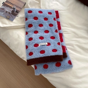 Detail of blue and red polka dot knit scarf with soft faux mink texture and brand label