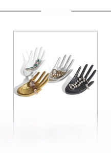 Macro detail of resin hand-shaped jewelry display stands in four colors with embossed texture