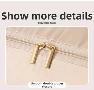 Detailed macro view of the premium golden double zipper on a beige storage bag