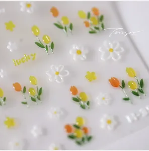 Macro detail of 3D embossed nail art stickers with tulip and daisy floral designs