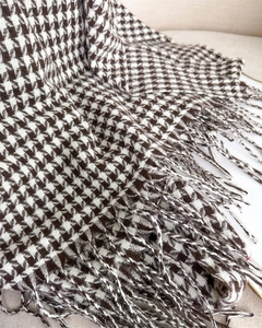 Detail shot of vintage houndstooth scarf with tassels in dark brown and beige tones