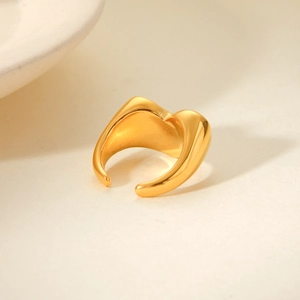 Macro detail of glossy gold plated stainless steel ring with wide irregular curves