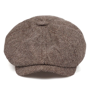 Detail shot of brown herringbone newsboy cap with textured wool blend fabric and top button