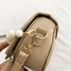 Close-up of khaki PU leather crossbody bag with golden hardware and pearl bead handle